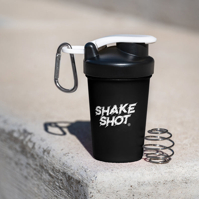 Black shake shot container with carabiner on concrete surface